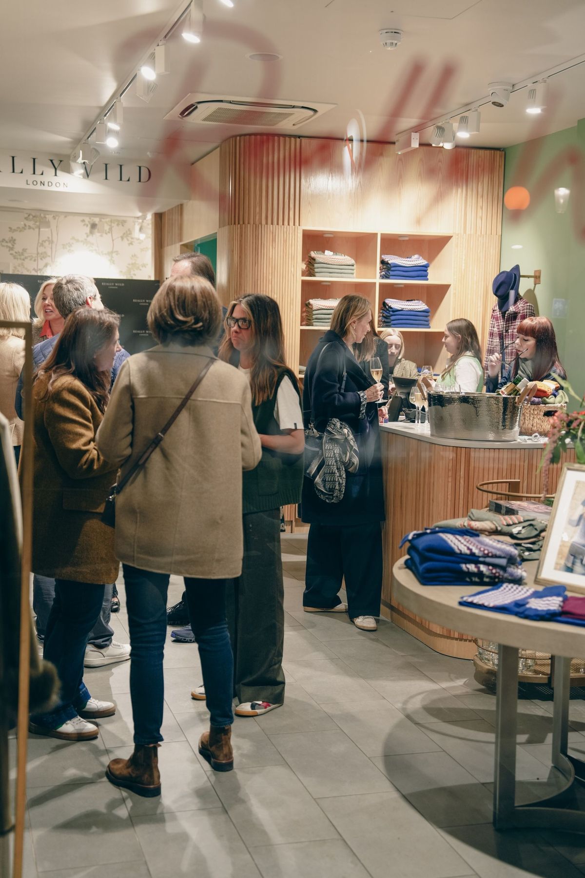 Guests chatting and sipping champagne on the shop floor at the Really Wild London Sloane Square launch, by REGO Creative