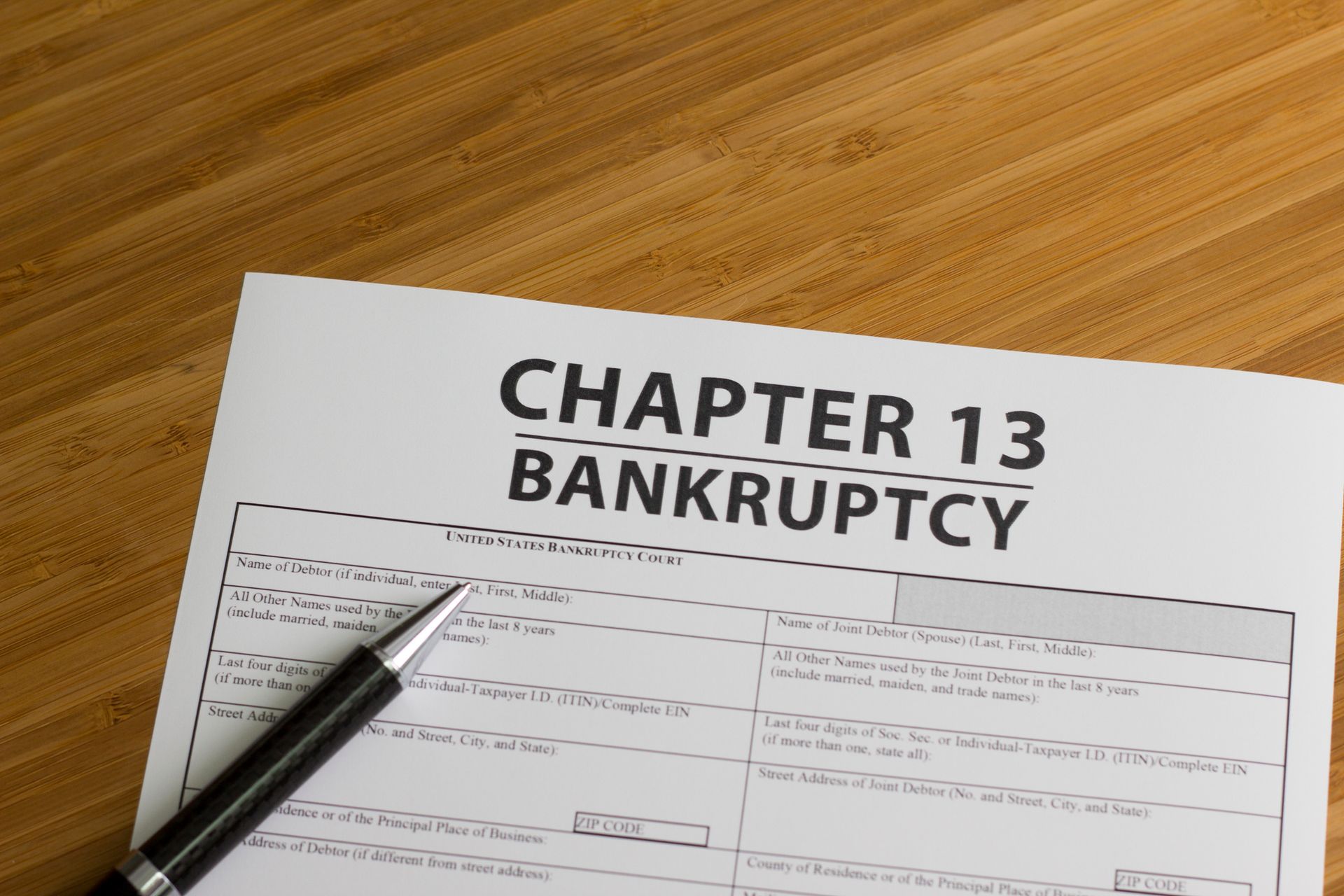 A pen is sitting on a piece of paper that says chapter 13 bankruptcy