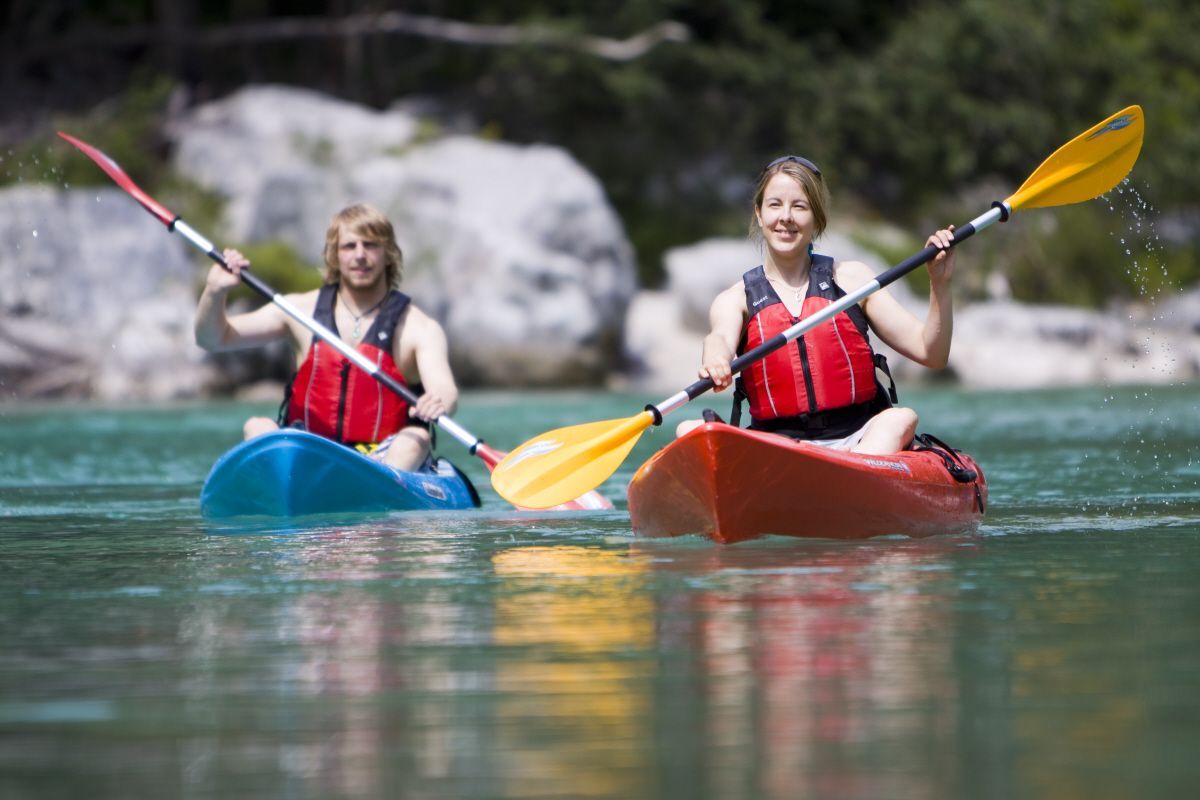 islander and wilderness systems sit on kayaks on the water