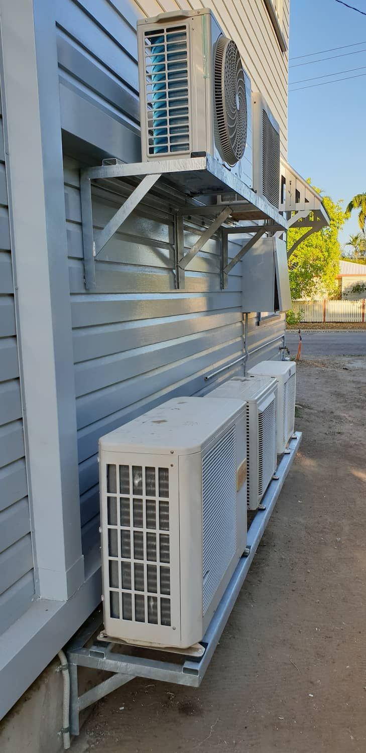 A Row Of Air Conditioners Mounted On The Side Of A Building — DJ Welding & Services in Currajong, QLD 