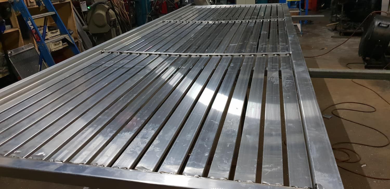 A Large Aluminum Table Is Sitting On Top Of A Wooden Floor In A Factory — DJ Welding & Services in Currajong, QLD 