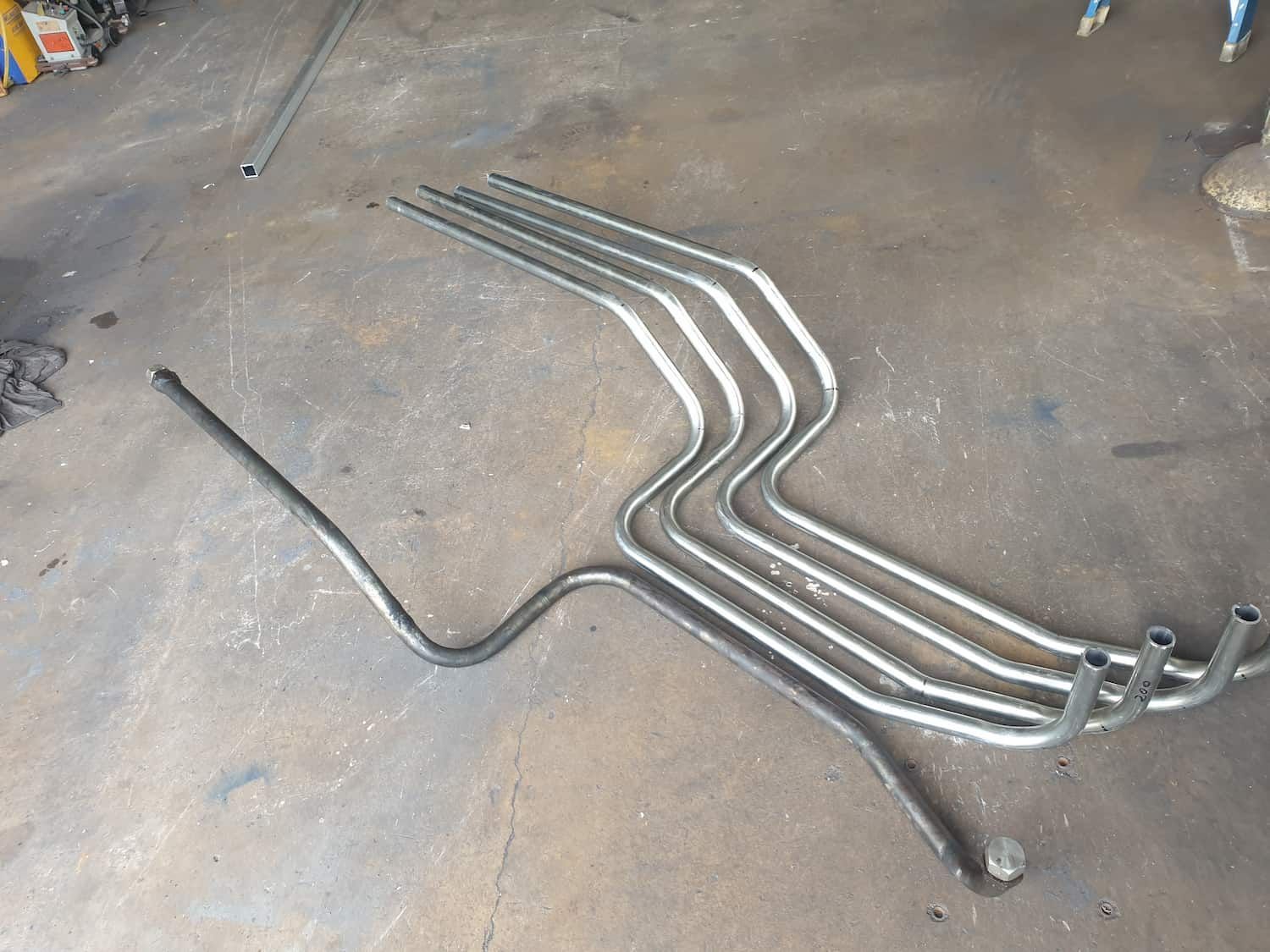 A Bunch Of Metal Pipes Are Laying On The Ground — DJ Welding & Services in Currajong, QLD 