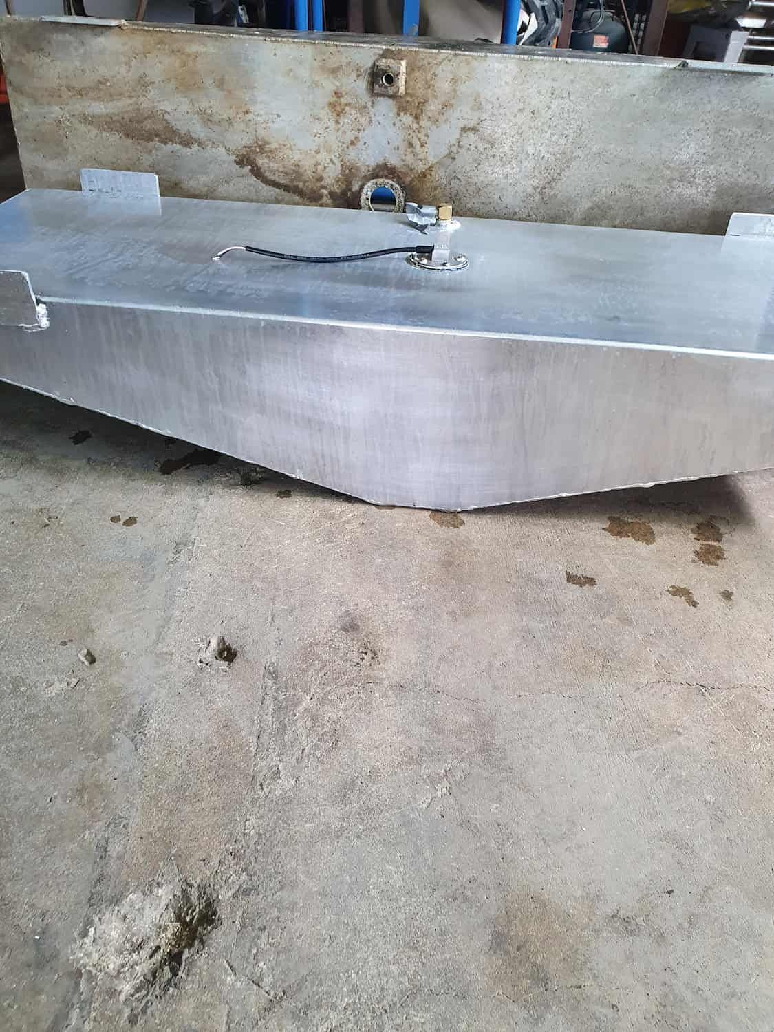 A Large Aluminum Tank Is Sitting On The Ground In A Garage — DJ Welding & Services in Currajong, QLD 