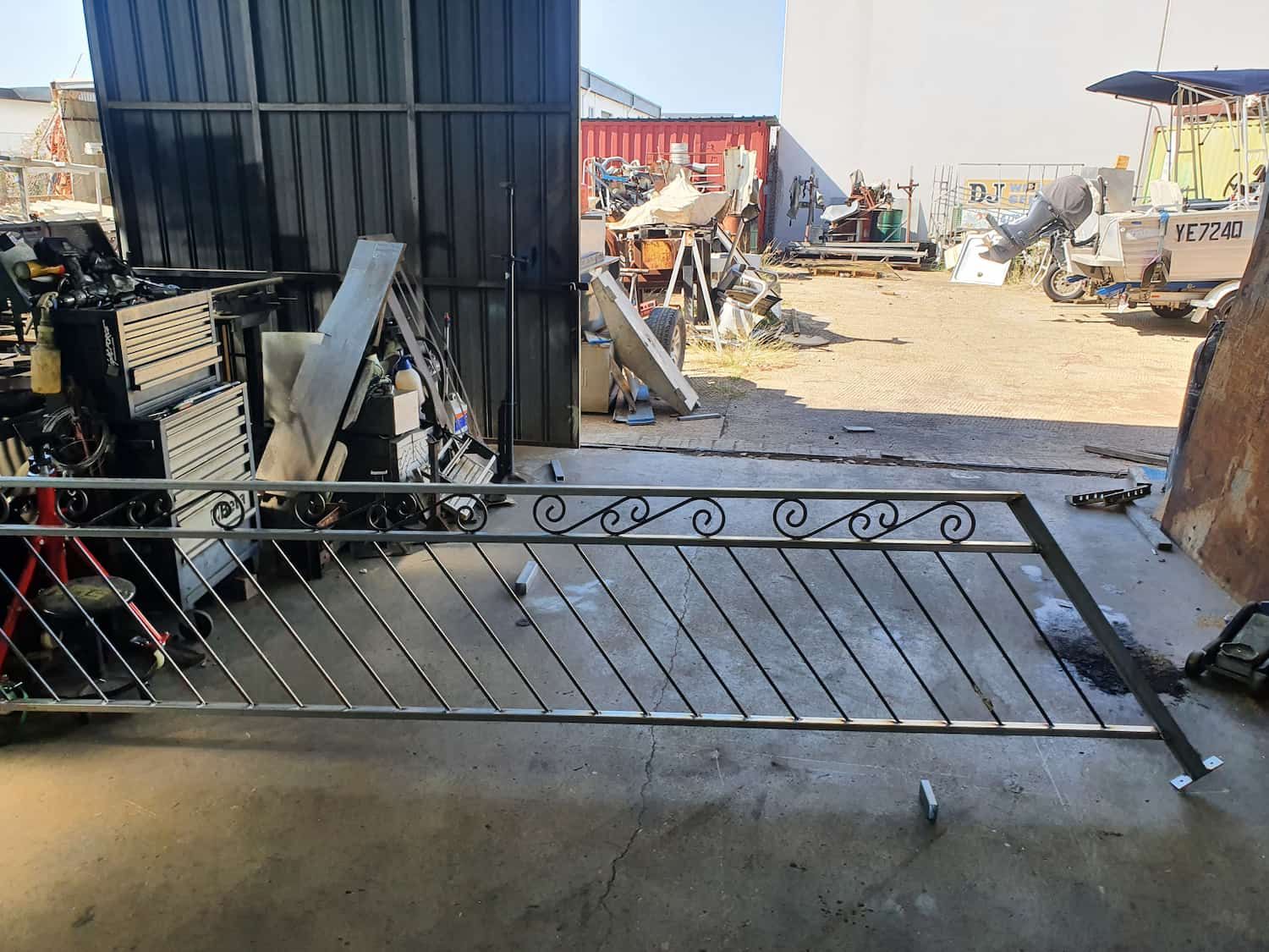A Metal Fence Is Sitting On The Ground In A Garage — DJ Welding & Services in Currajong, QLD 