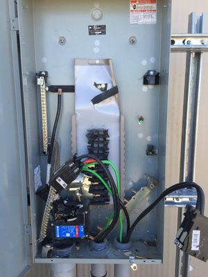 Open electrical panel with exposed wiring and components inside.