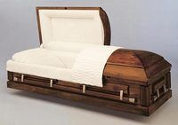 a wooden casket with the lid open on a white surface .