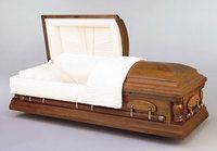 a wooden casket with the lid open on a white surface .
