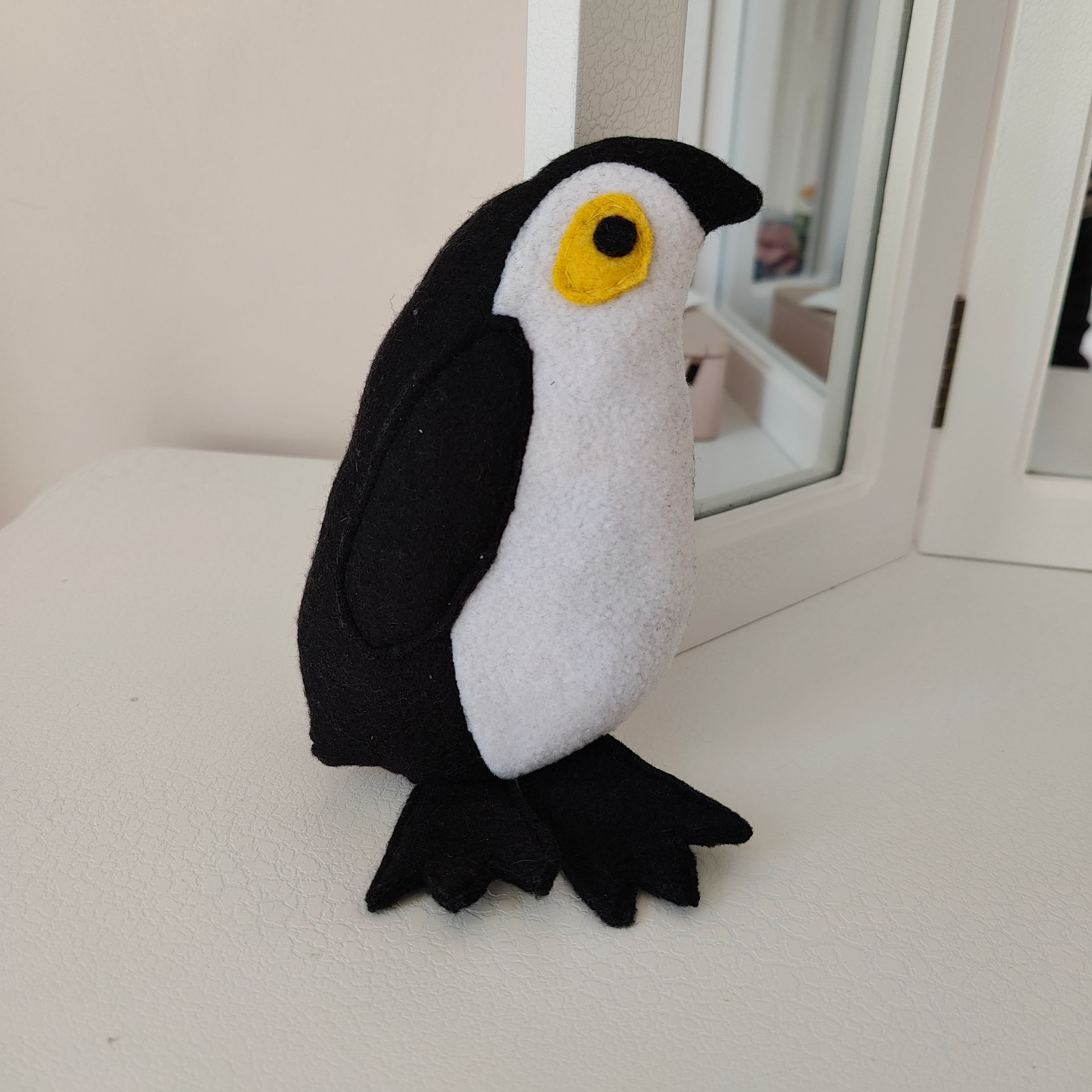 felt penguin by a mirror
