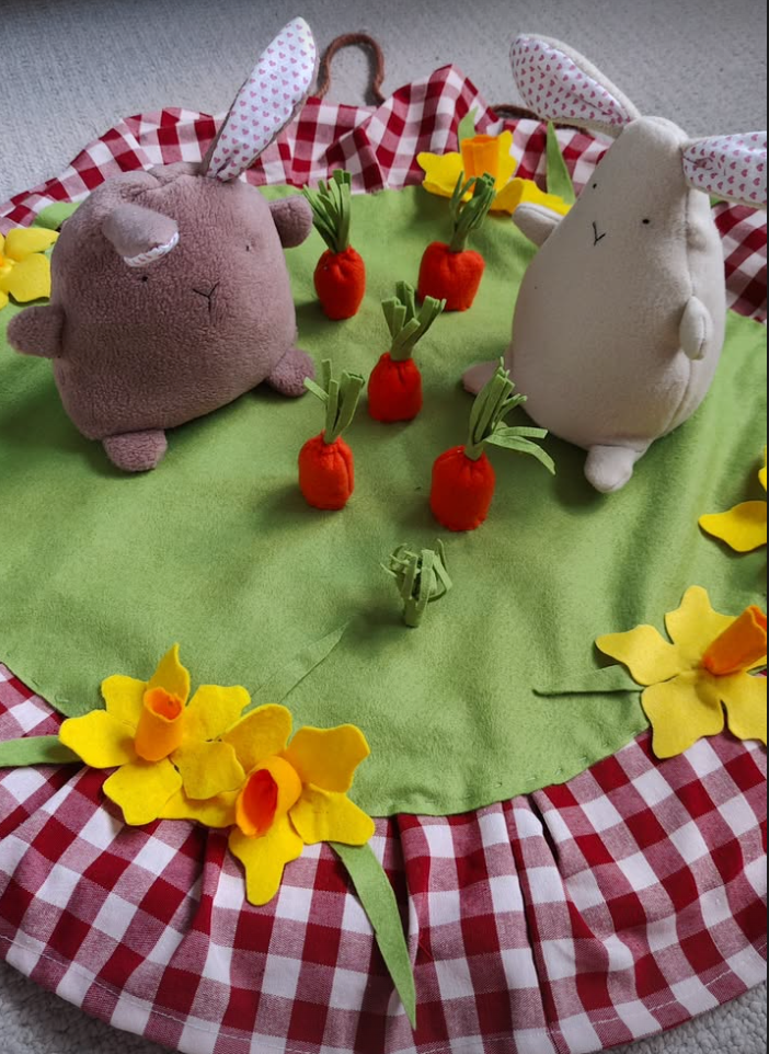 fabric rabbits, felt carrots and daffodils on green and red checkered fabric