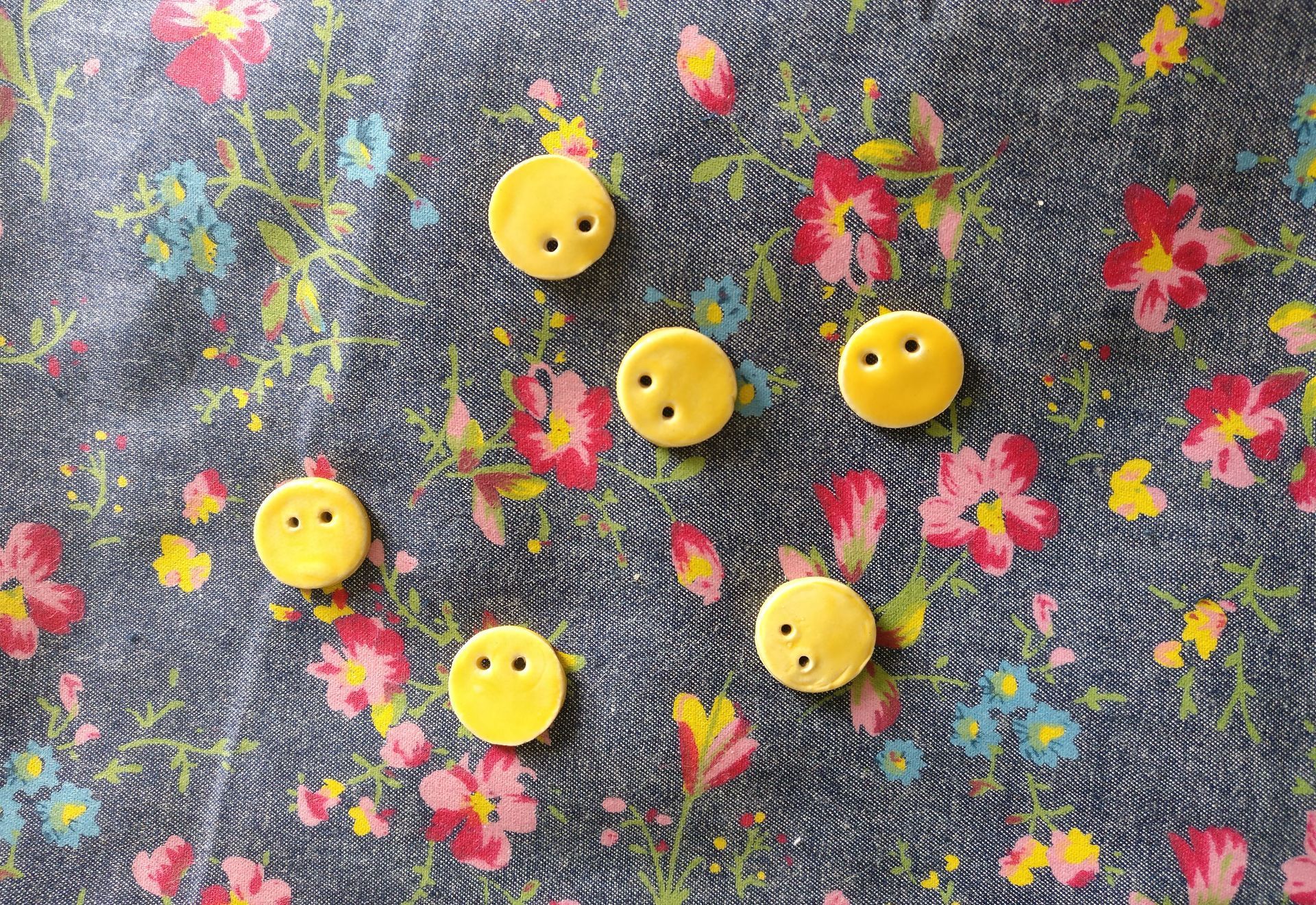 yellow glazed ceramic buttons on a floral fabric

