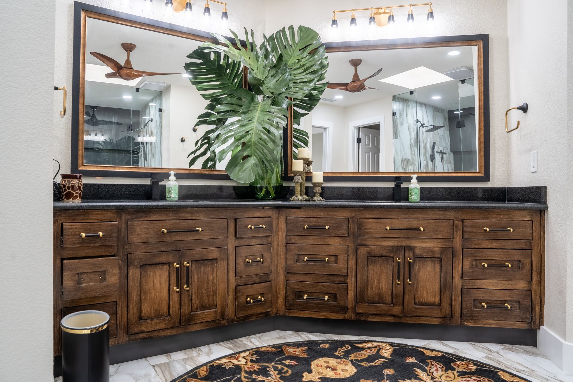 Bathroom with wooden vanity, large mirror, and tropical plant.