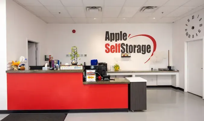 Apple Self Storage reception desk with red counter in a clean white lobby