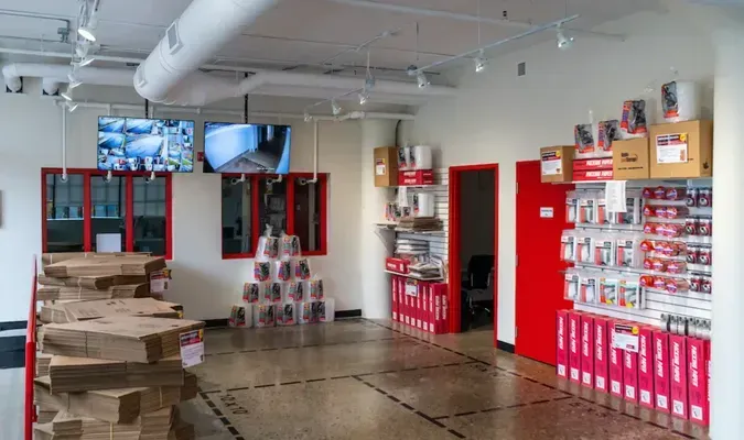 Interior shop with red and white fixtures, security screens, and packaged products for sale.