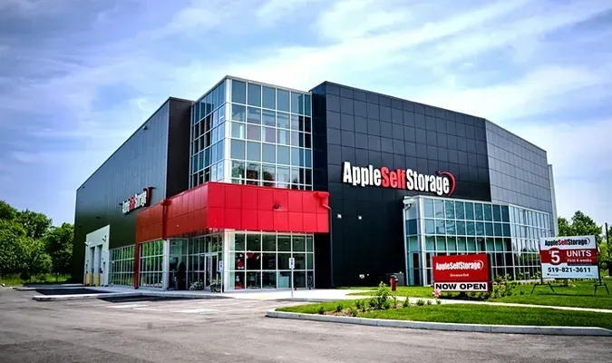 Apple Self Storage facility exterior. Black and red building with large windows.