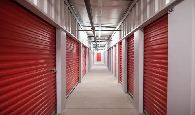 Long corridor of red storage unit doors in a self-storage facility