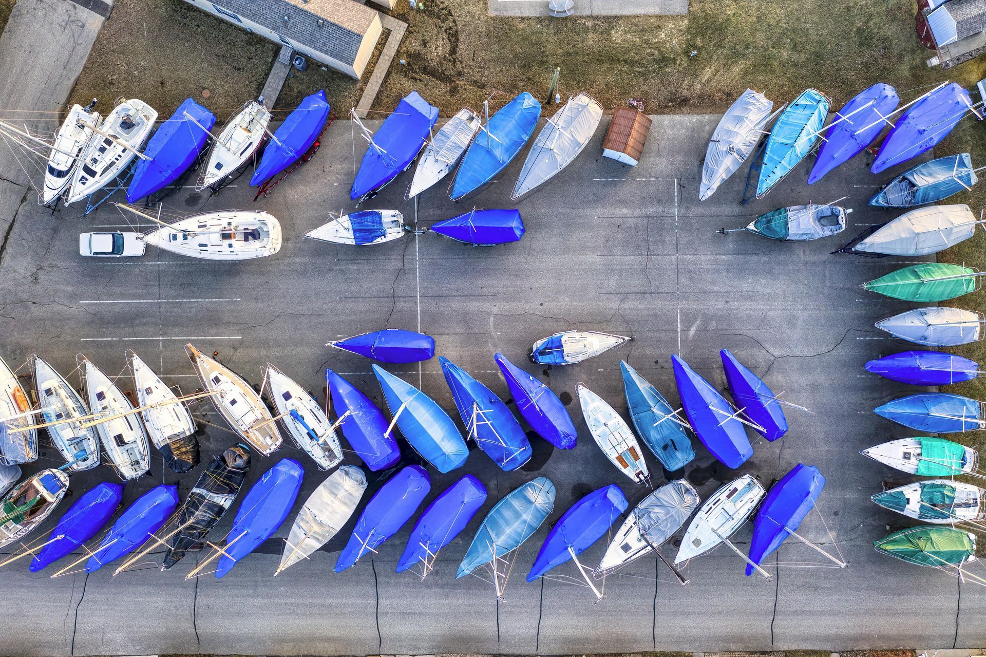Aerial view of many blue and white kayaks lined up in rows on a concrete dock