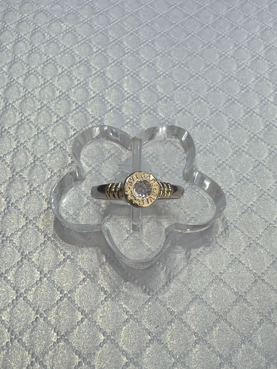 Anillo con piedra central transparente, engastada en una banda de metal amarillo