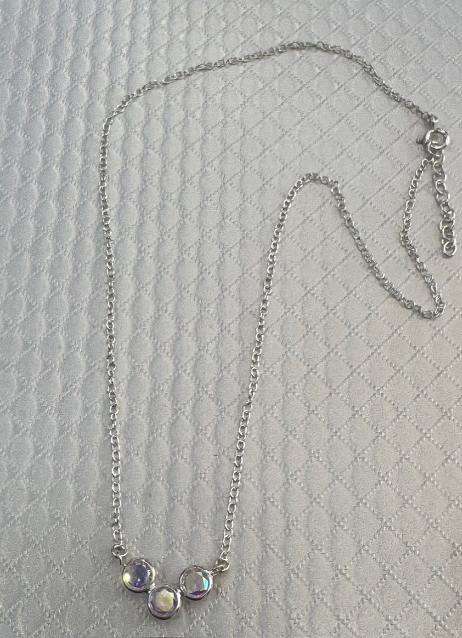 Collar de plata con tres piedras de color azul claro.