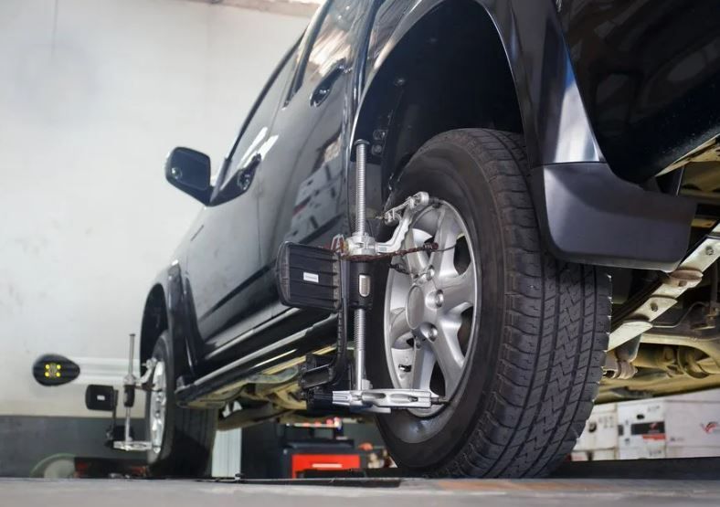 A Car Wheel is Being Aligned With a Machine in a Garage — Wollongong Auto Excellence In Wollongong, NSW