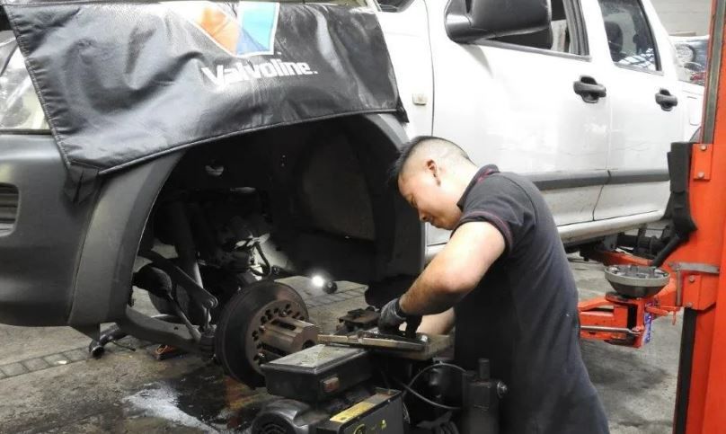 A Mechanic Fixing Brakes in a Mechanic Shop — Wollongong Auto Excellence In Wollongong, NSW