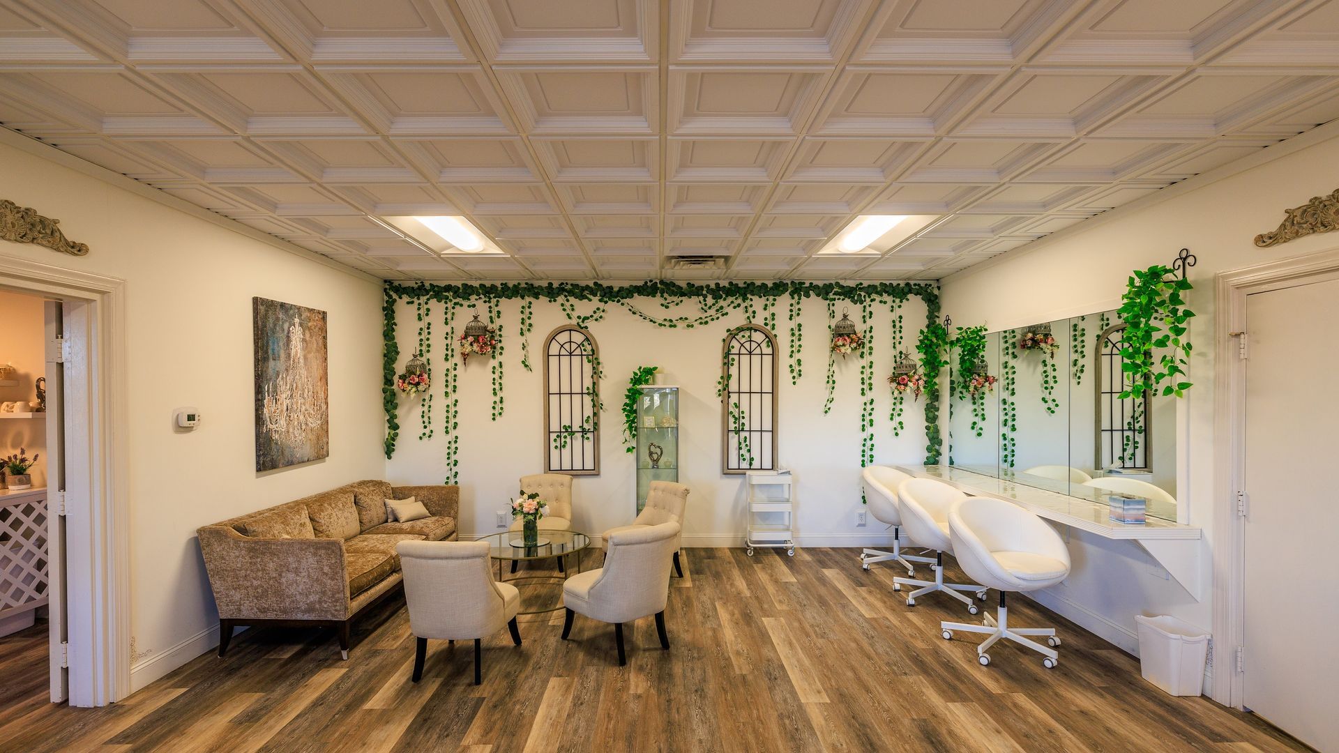 Hair salon interior with seating area, mirrors, and floral decorations.