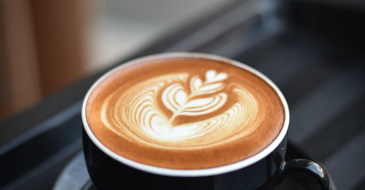 Cup of coffee with  leaf design in the milk