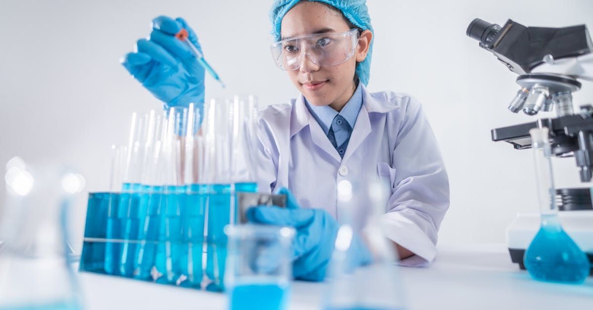 Scientist in a lab adding a liquid to a test tube