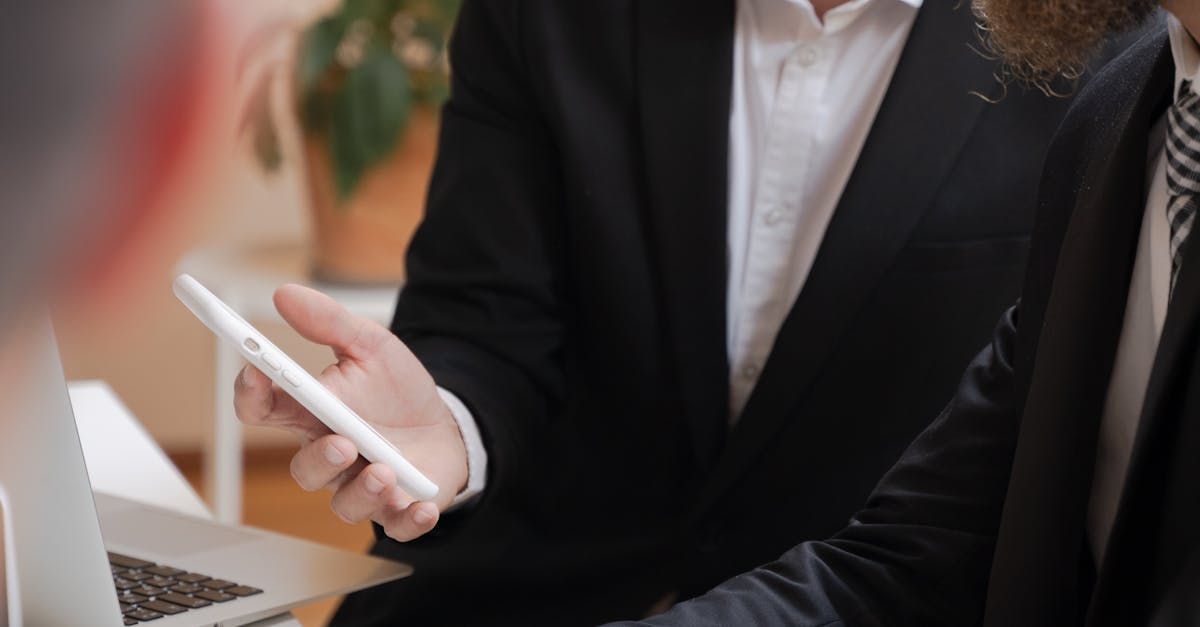 Man in a black suit holding a phone