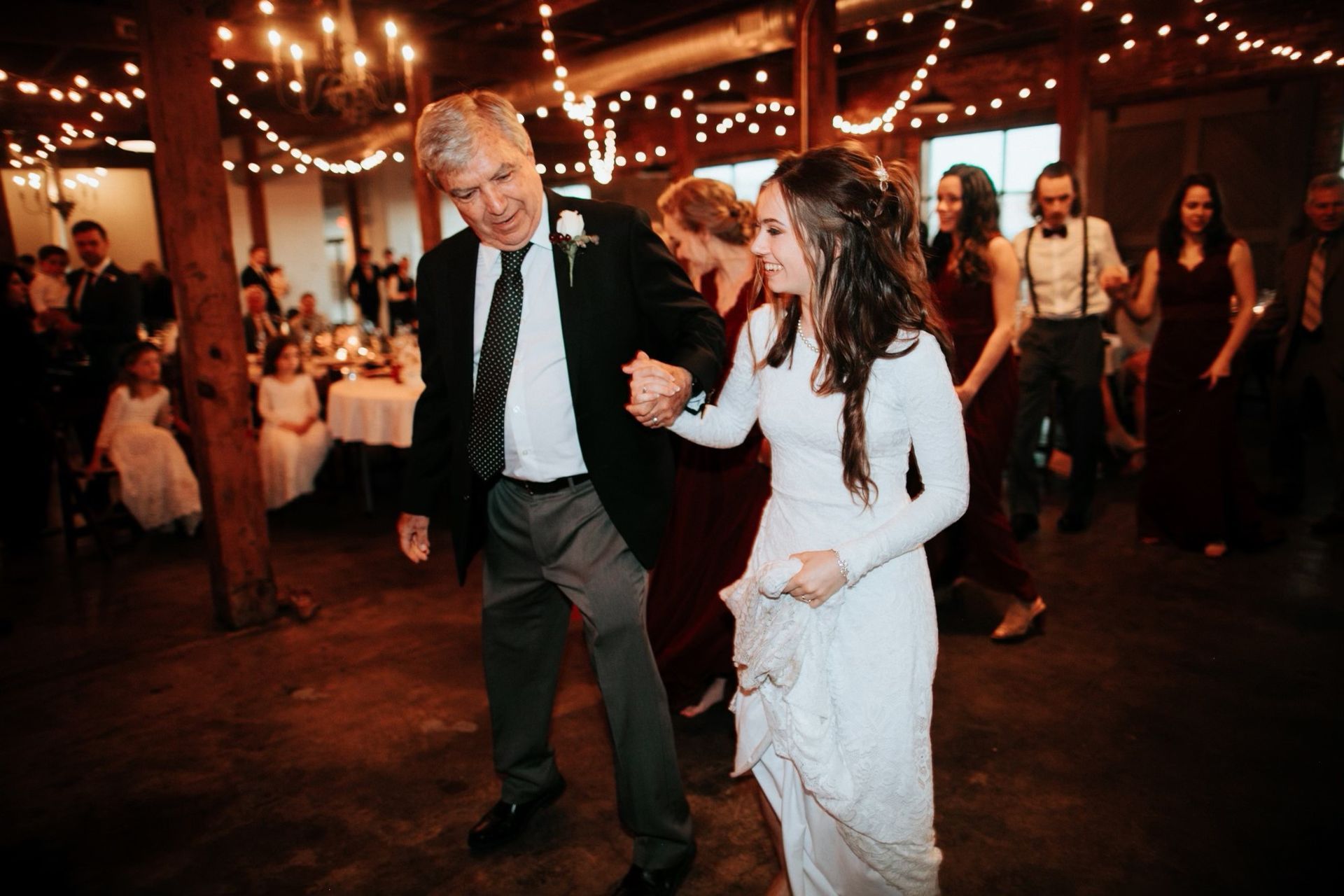 A bride at her wedding dancing a traditional dance mixer
