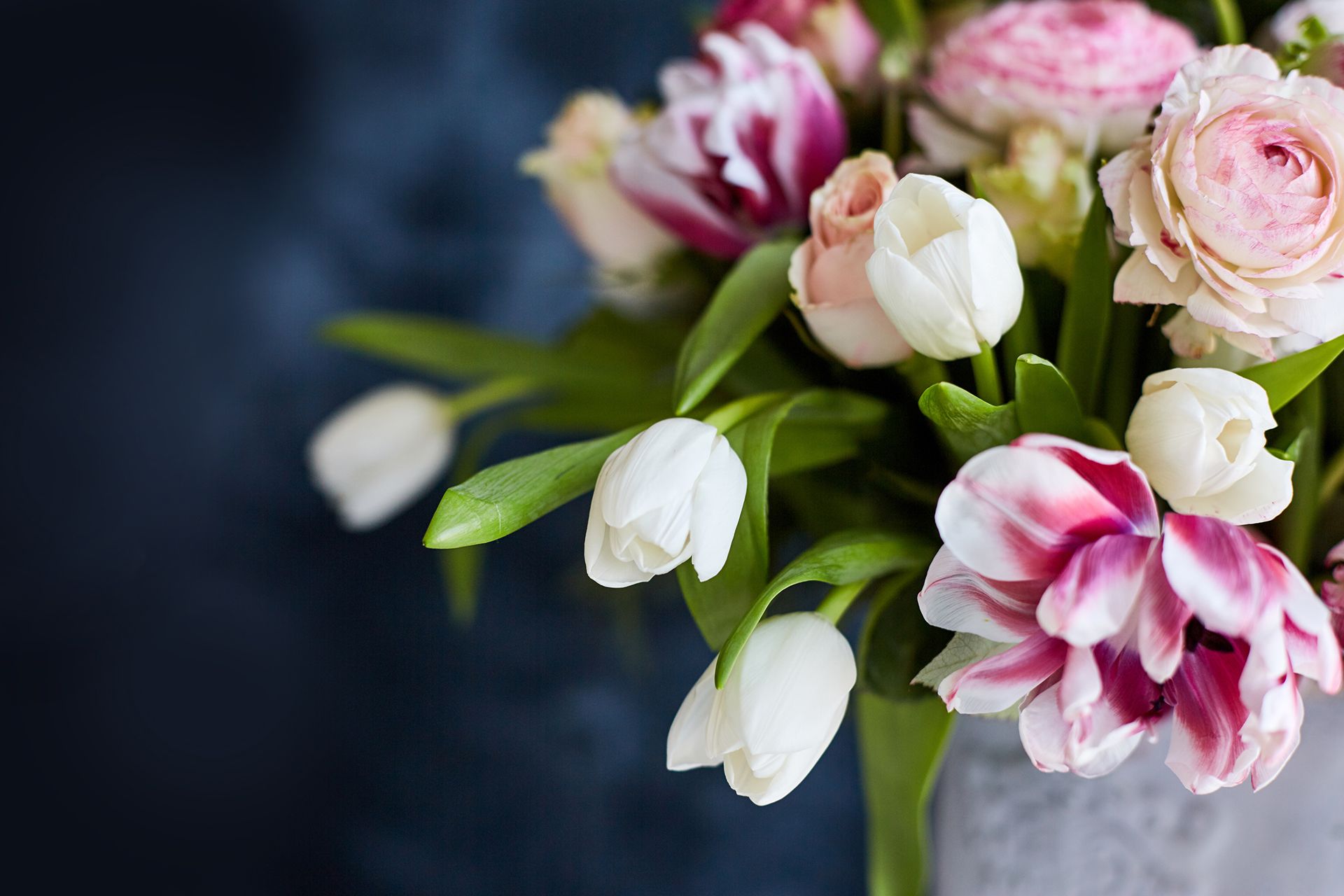 A bouquet of pink and white flowers in a vase on a table.