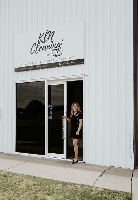 A white building with a sign that says kln cleaning on it.