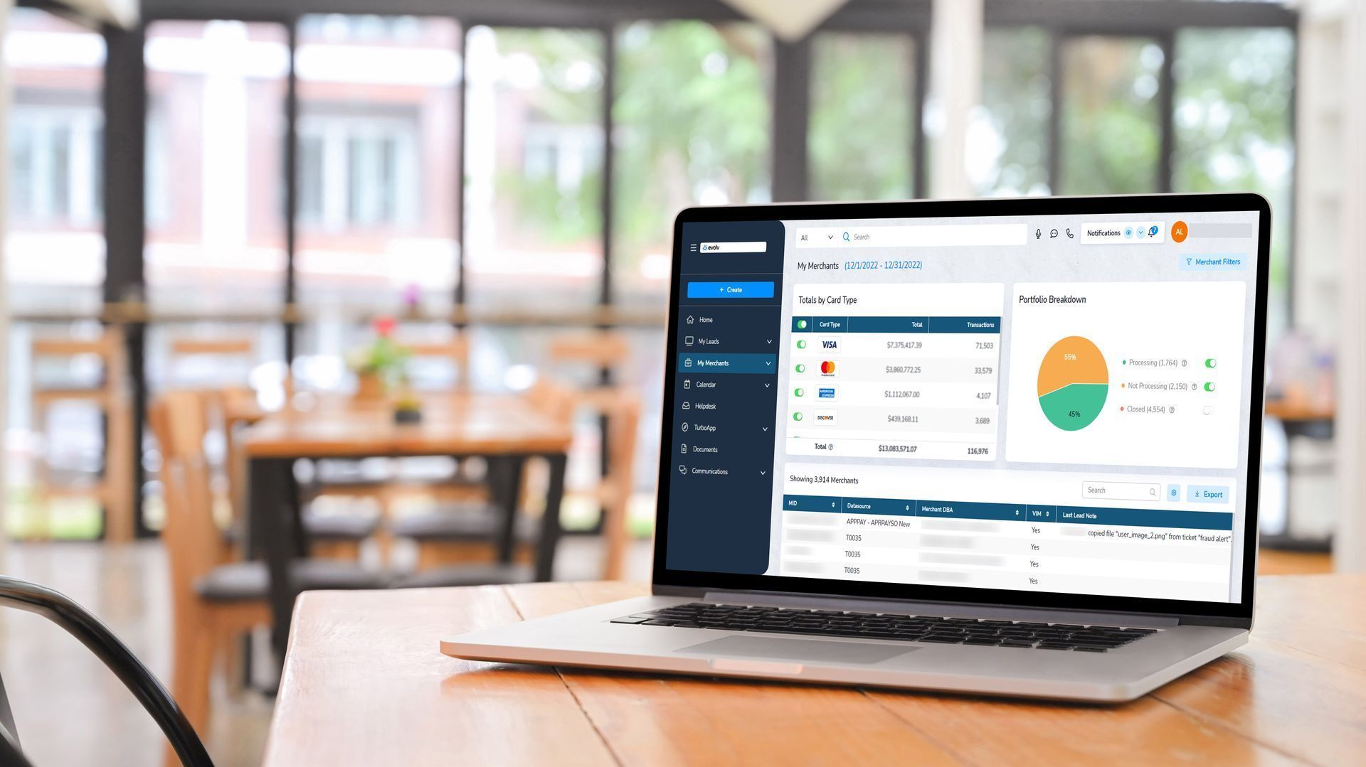 Laptop on a café table displaying an analytics dashboard in front of a blurred café interior