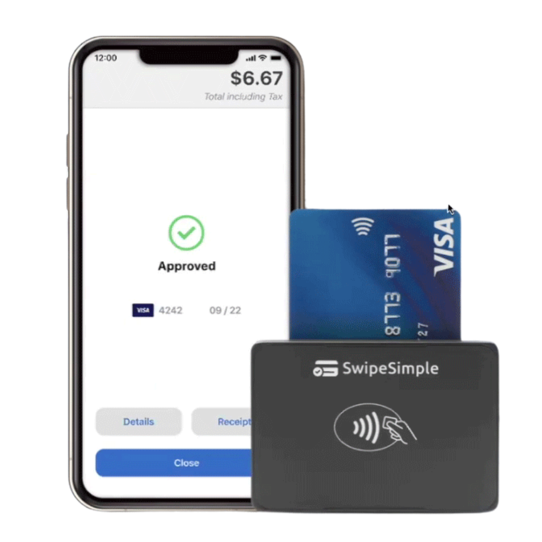 Smartphone showing approved payment next to blue Visa card and black contactless card reader