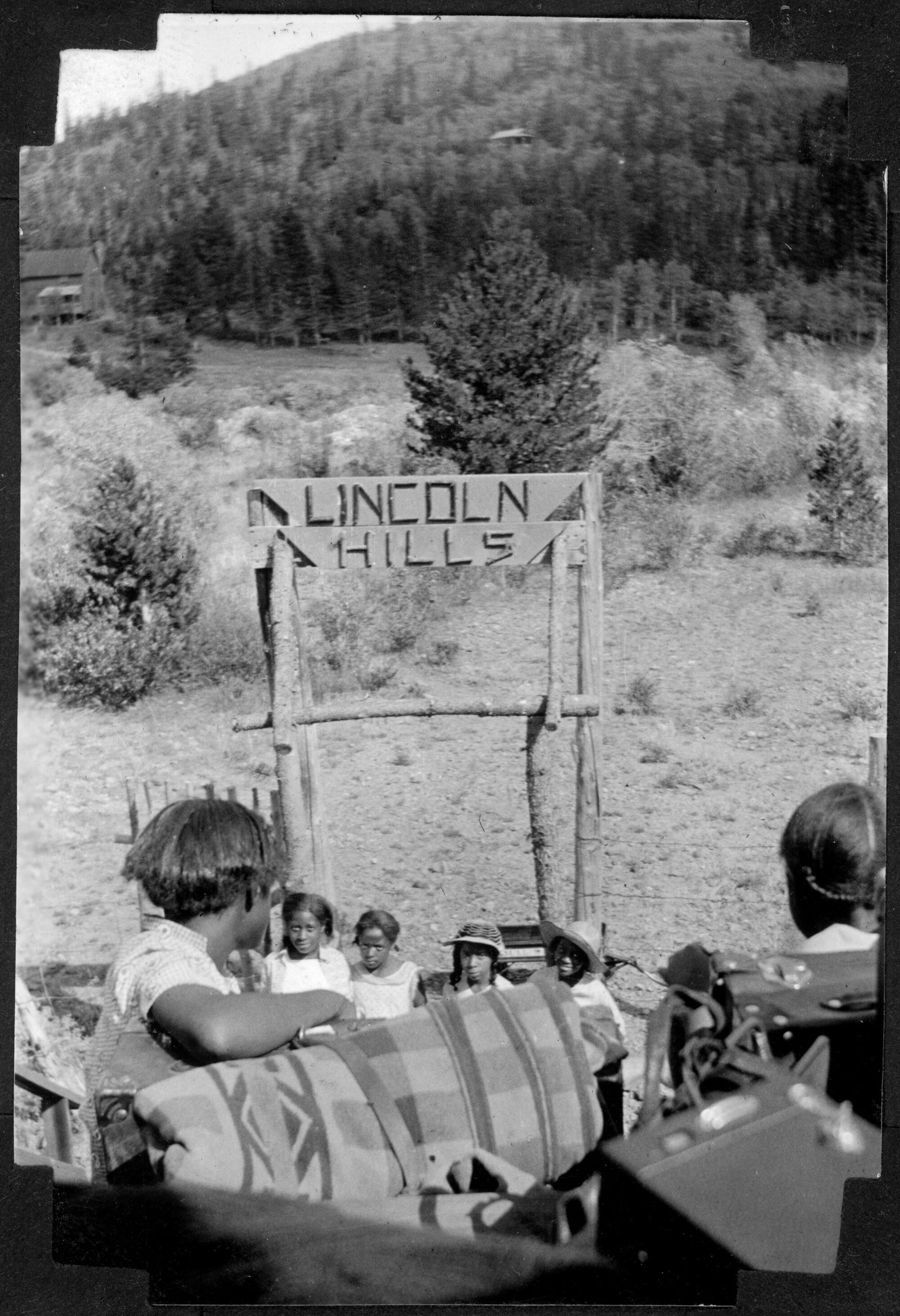 African American teenage campers stand at the entrance
of Lincoln Hills, Colorado.