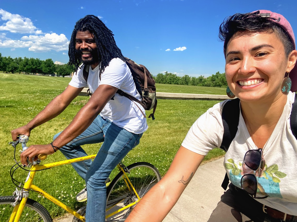 A man and a woman are riding bicycles in a park.