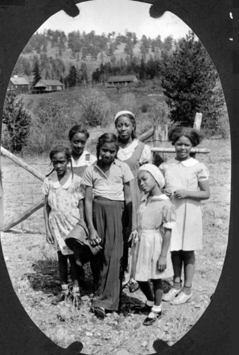 A black and white photo of a group of children posing for a picture