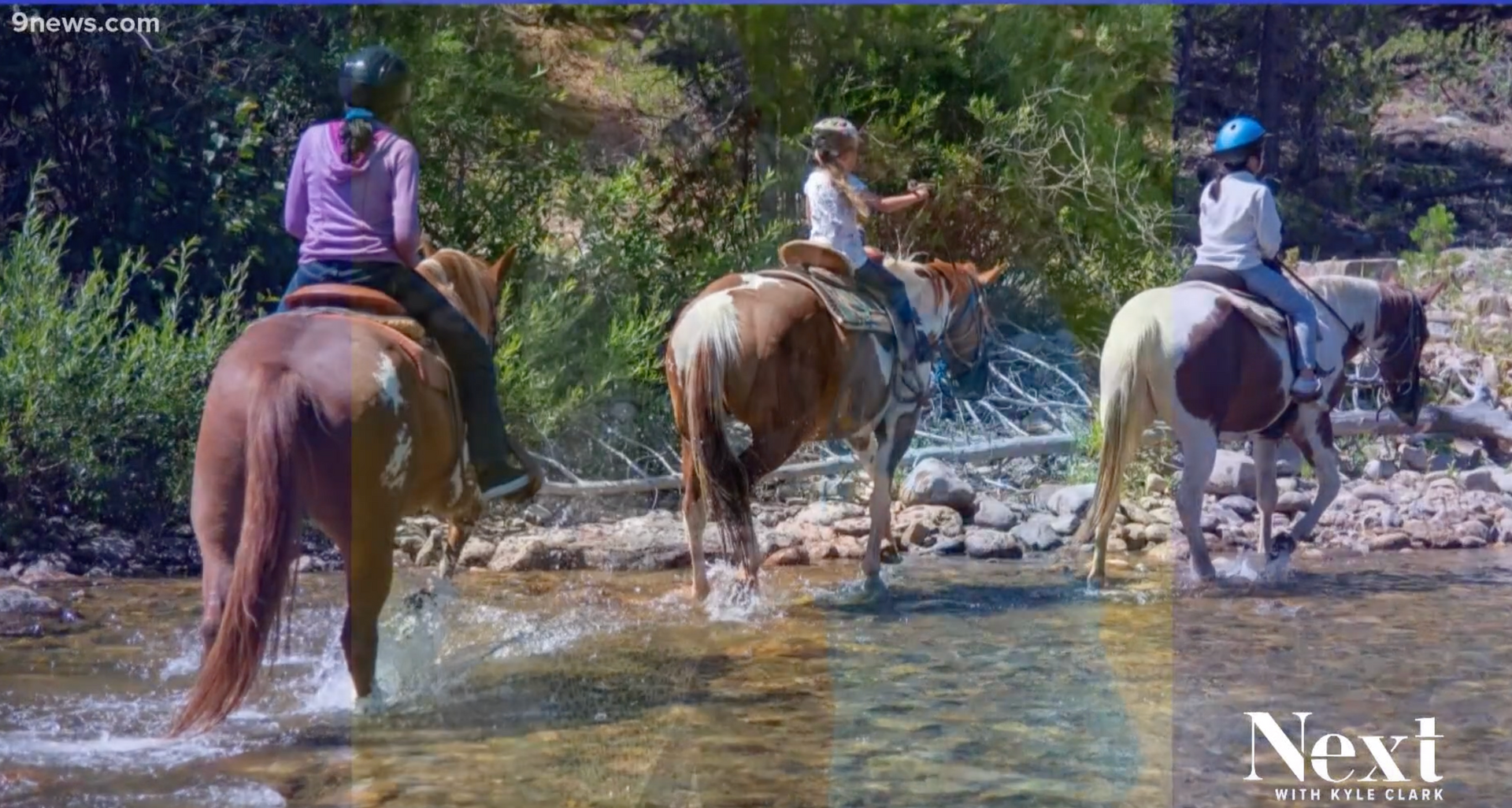 A group of people are riding horses across a river.