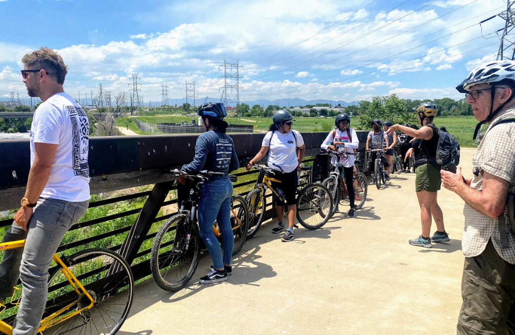 A group of people are riding bicycles on a bridge.