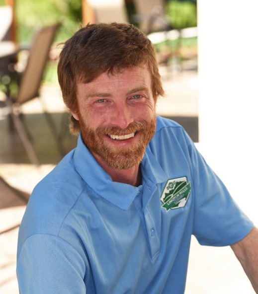 A man with a beard is wearing a blue polo shirt