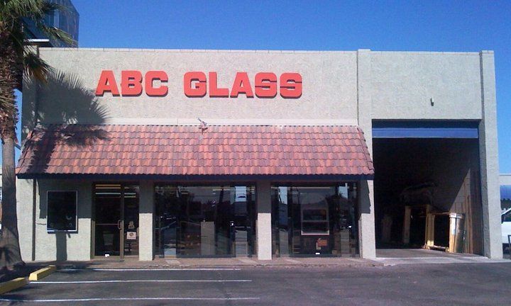 ABC Glass storefront with red letters and awning, beige building, open garage door.