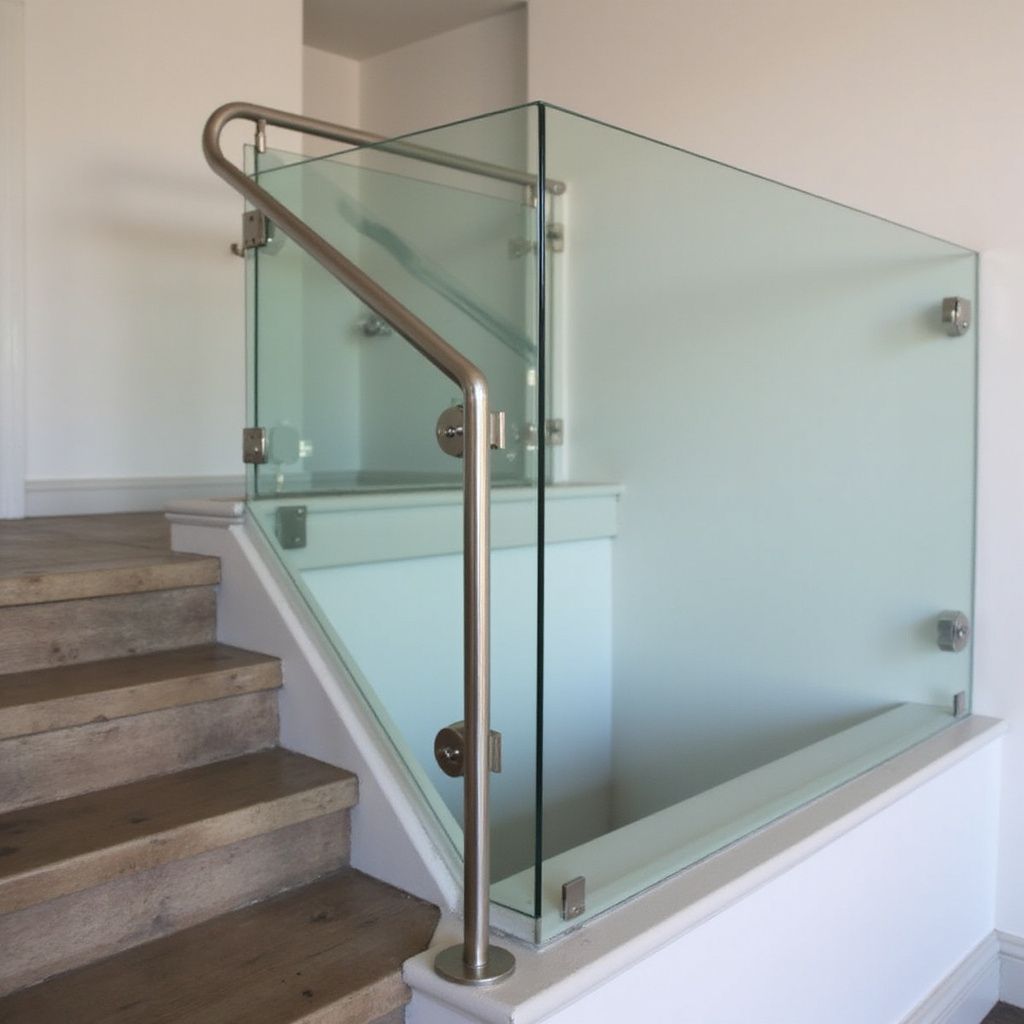 Glass and metal railing on a staircase with wooden steps.