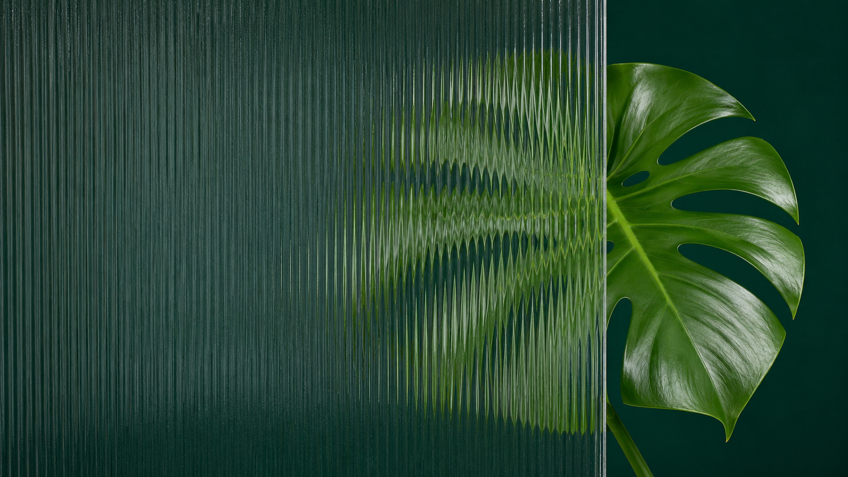 Green textured glass panel with a large tropical leaf peeking from the right side