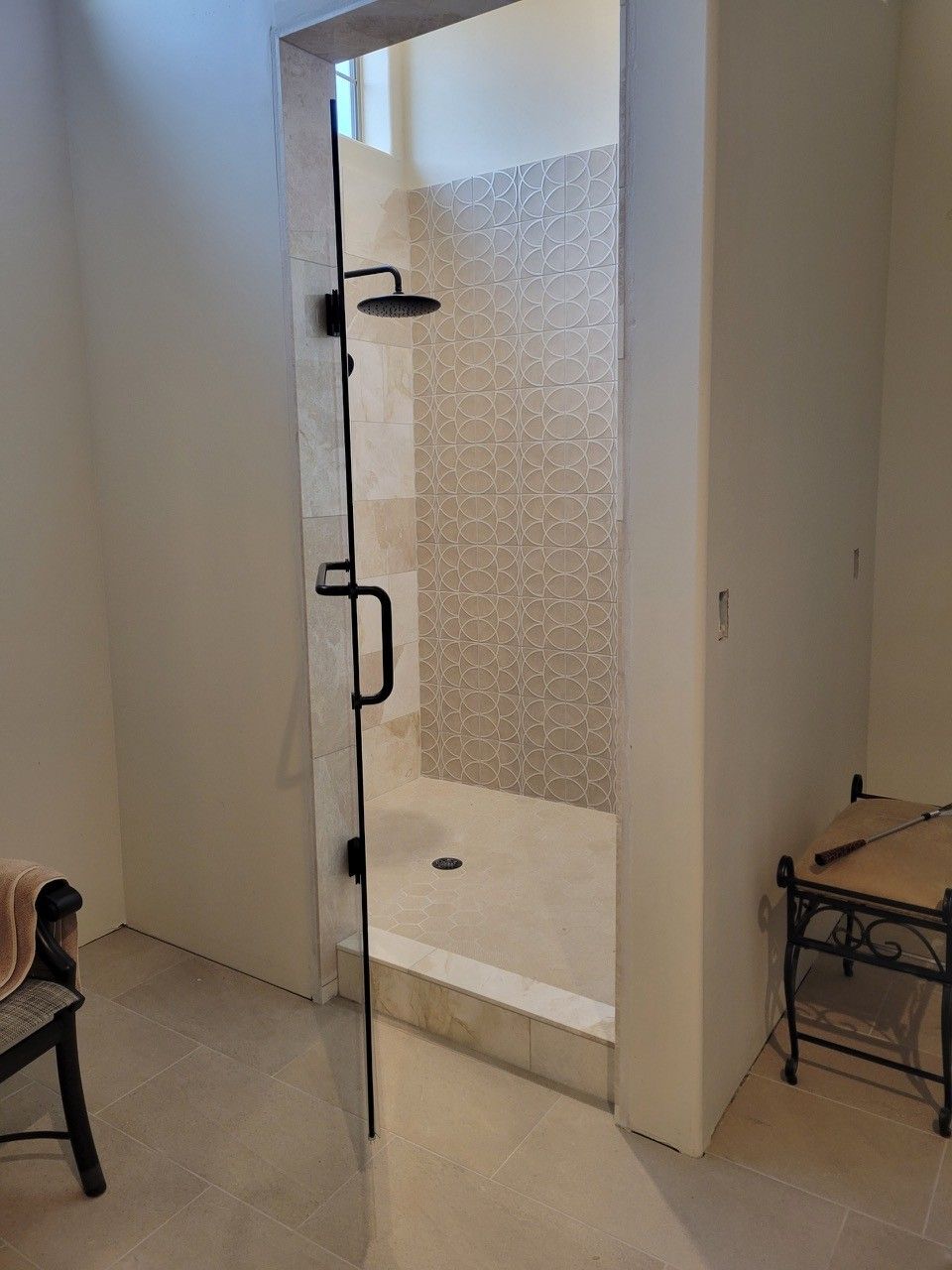 Open shower stall with glass door in a minimal bathroom.