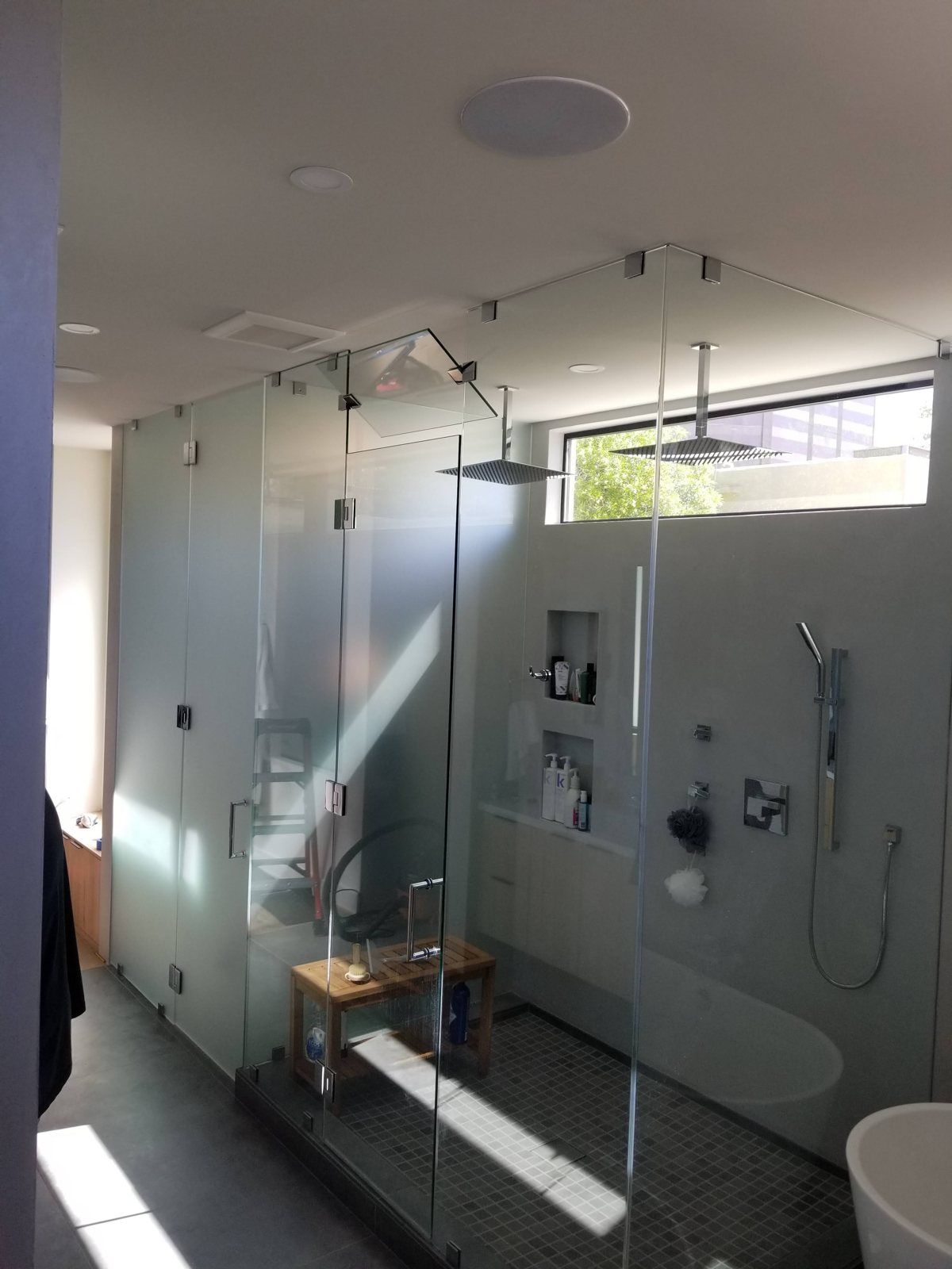 Large frameless corner glass shower enclosure with transom glass and matte black hardware in a Phoenix home
