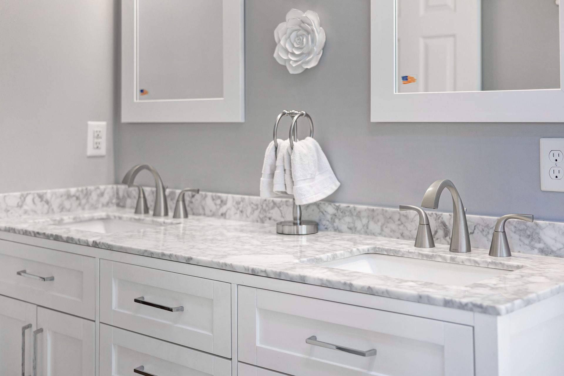 Bright white double bathroom vanity with marble countertop, mirrors, and chrome faucets