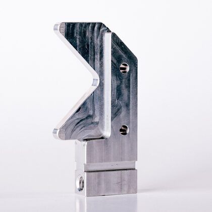 Aluminum metal bracket with a V-shaped cutout and two screw holes, viewed from the side, on a white background.