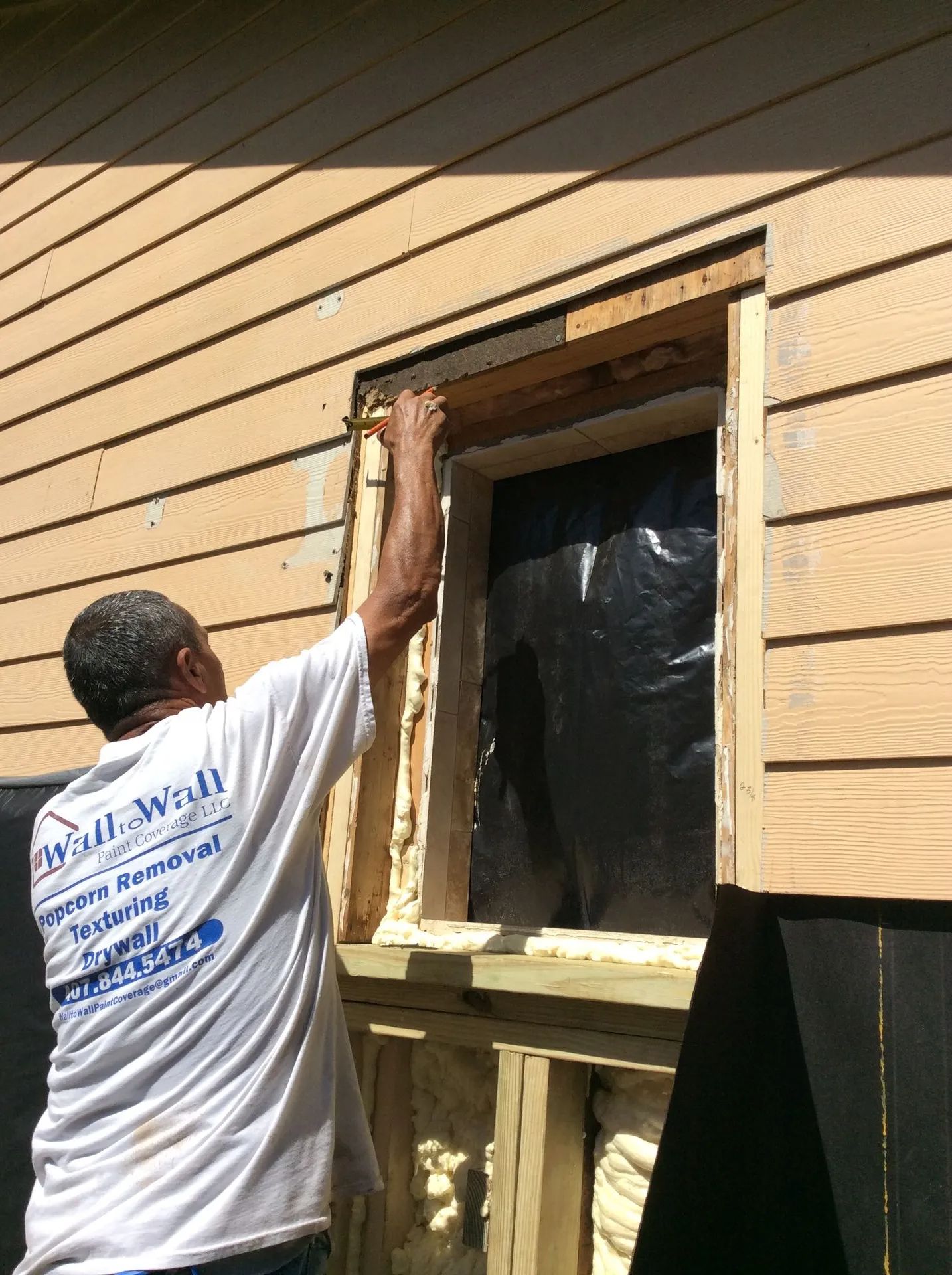 man applying insulation on window frame
