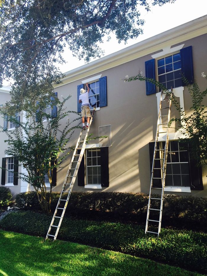 man fixing a window from the outside