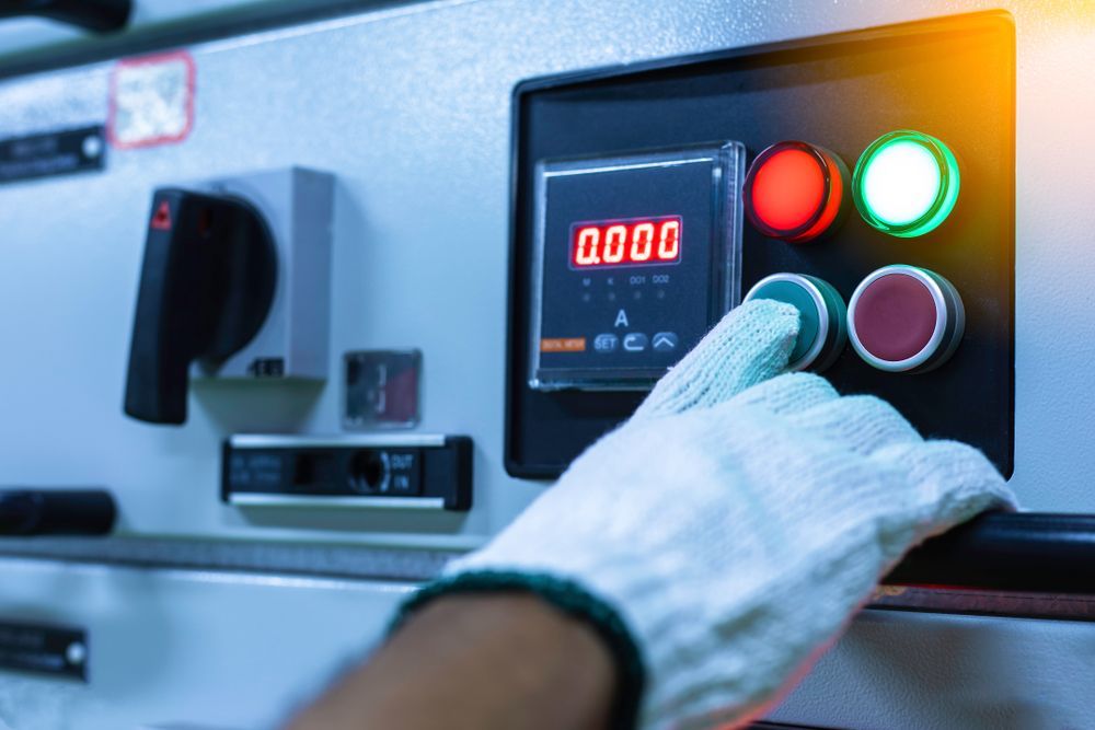 Gloved Hand Pressing a Green Button on an Electrical Control Panel — Industry Fire Services in Port Douglas, QLD
