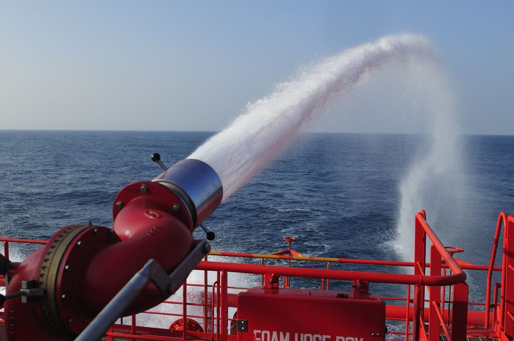 Red Fire Monitor Spraying White Foam Over the Ocean — Industry Fire Services in Atherton Tablelands, QLD